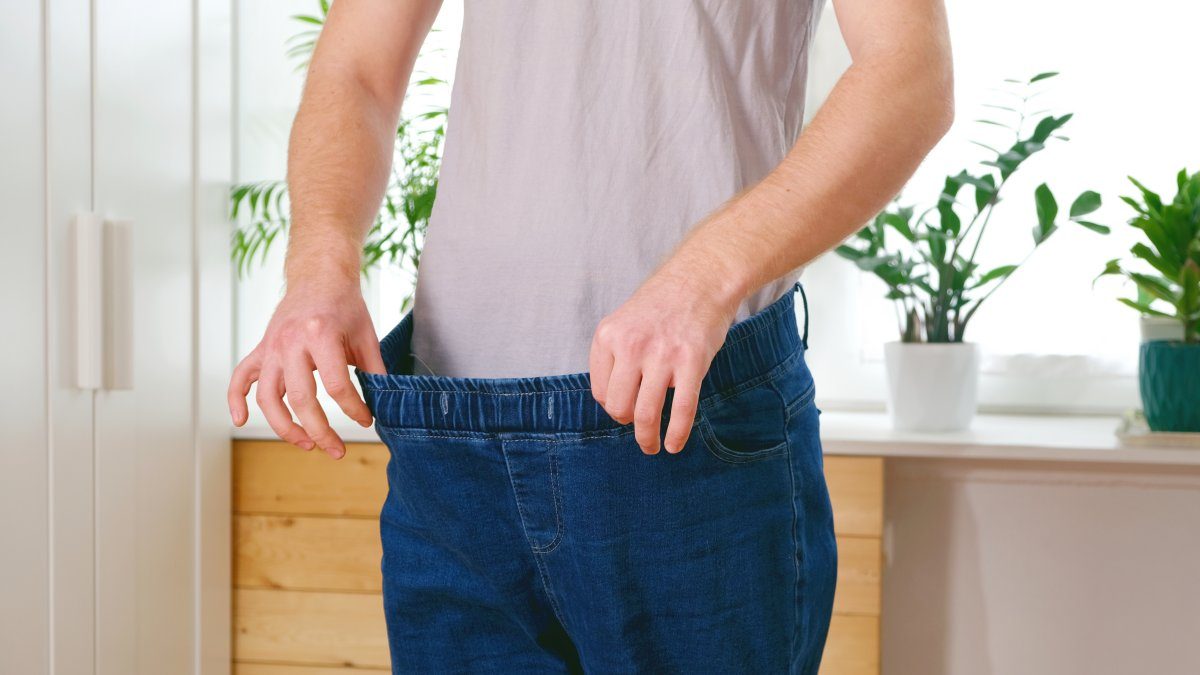 Man i för stora jeans efter att ha gått ner 10 kg